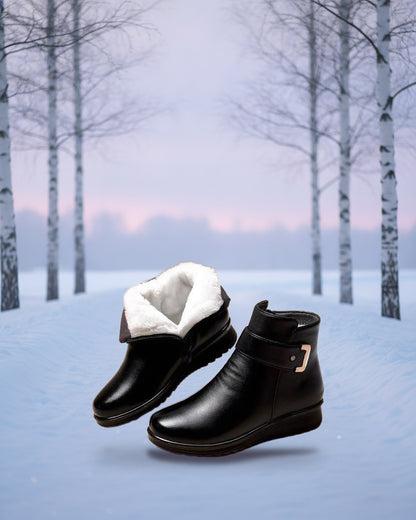 Black ankle boots with white fur lining on a snowy path